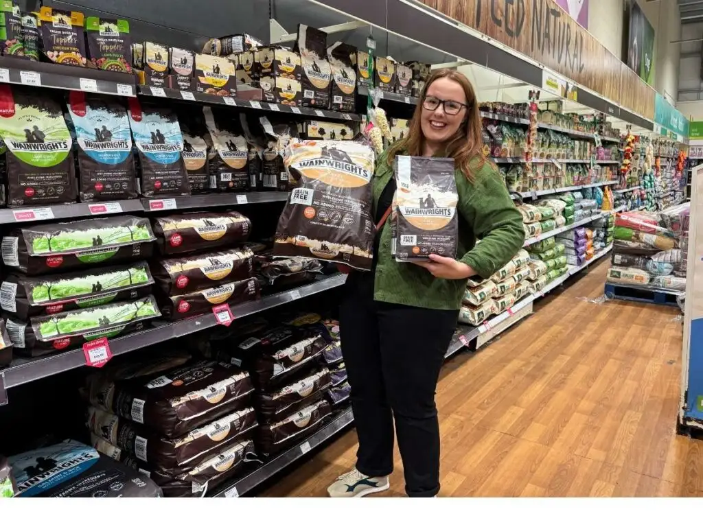 Chloe holding bulk bags of dog food to save money at Pets at Home