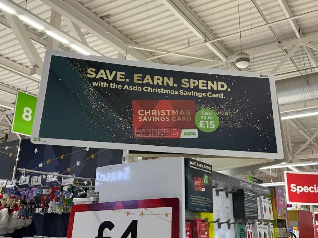 A sign in Asda supermarket showing the Christmas savings card with Asda rewards