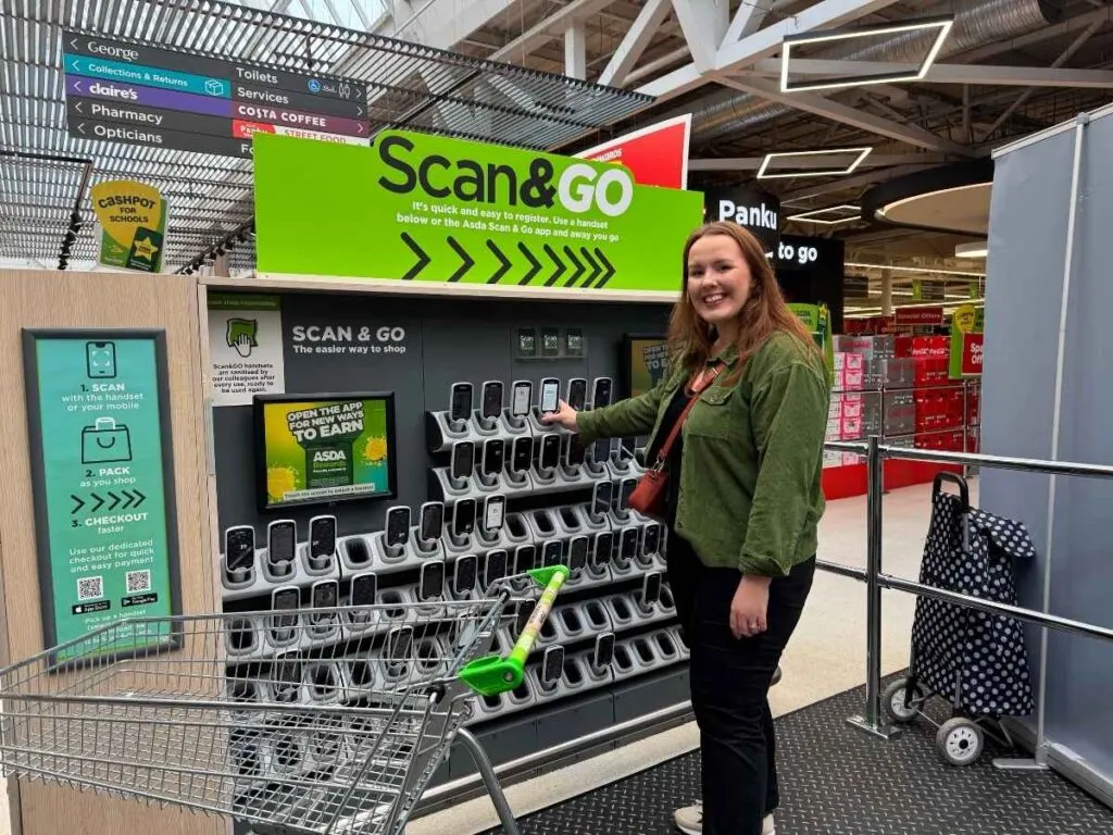 Chloe from Chloe's deal club standing next to the Asda Scan & Go in-store to save money at Asda