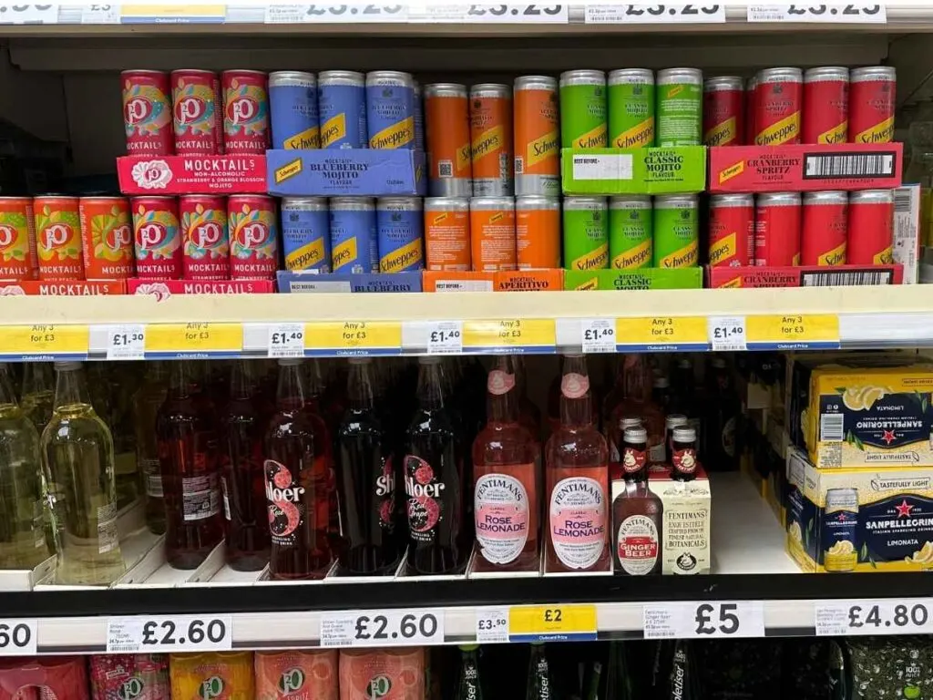 A Tesco supermarket aisle showing drinks discounted with the Tesco Clubcard app to save money