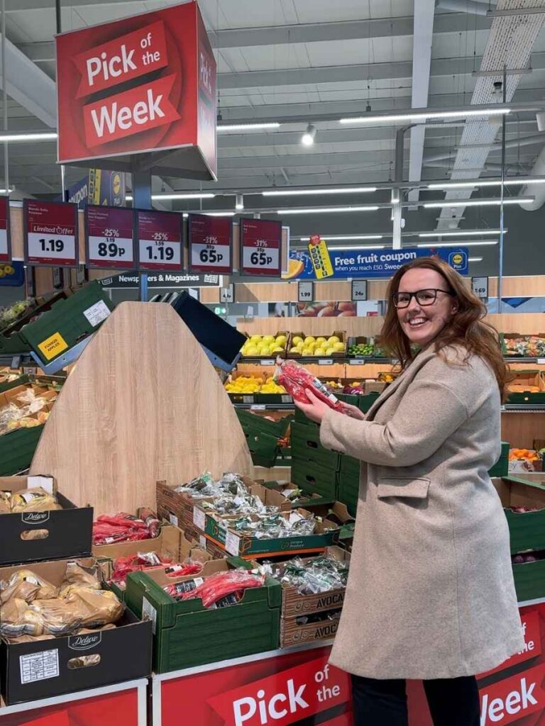 Chloe holding fruit and veg at Pick of the Week in Lidl to save money