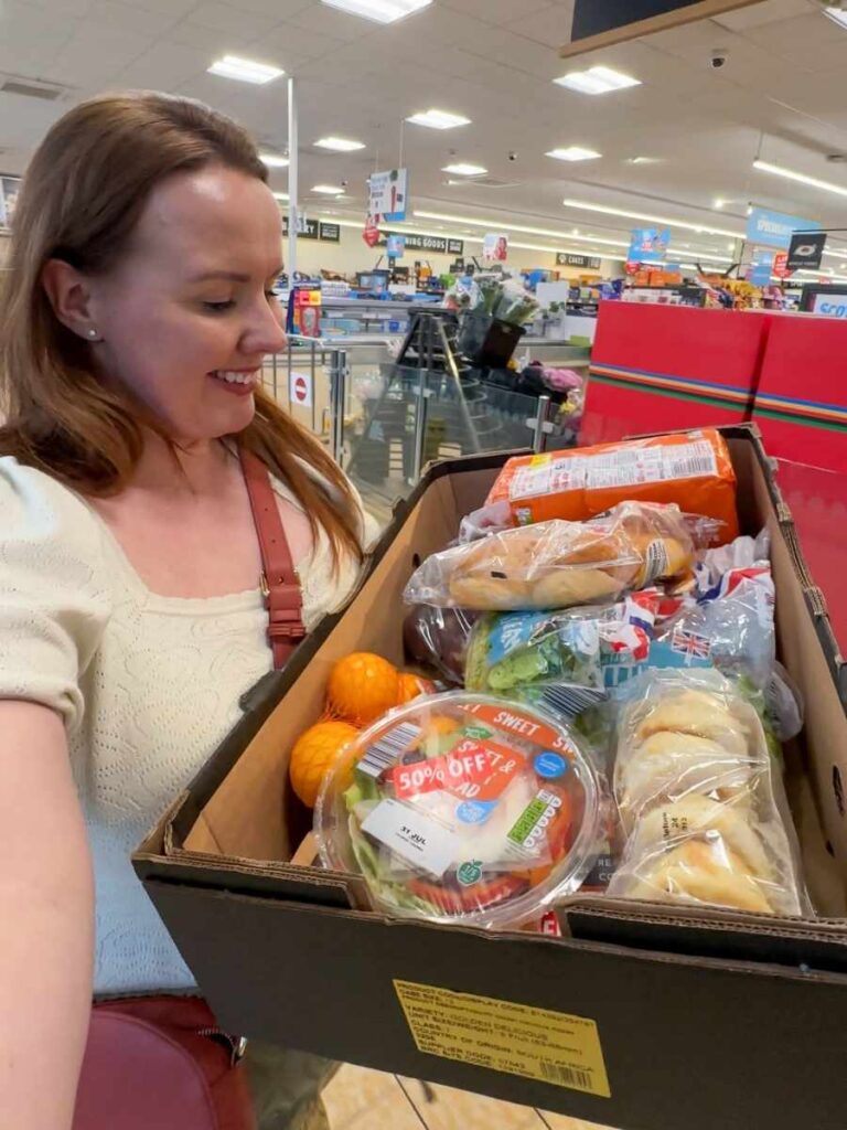 Chloe holding a Too Good To Go box from Aldi to save money