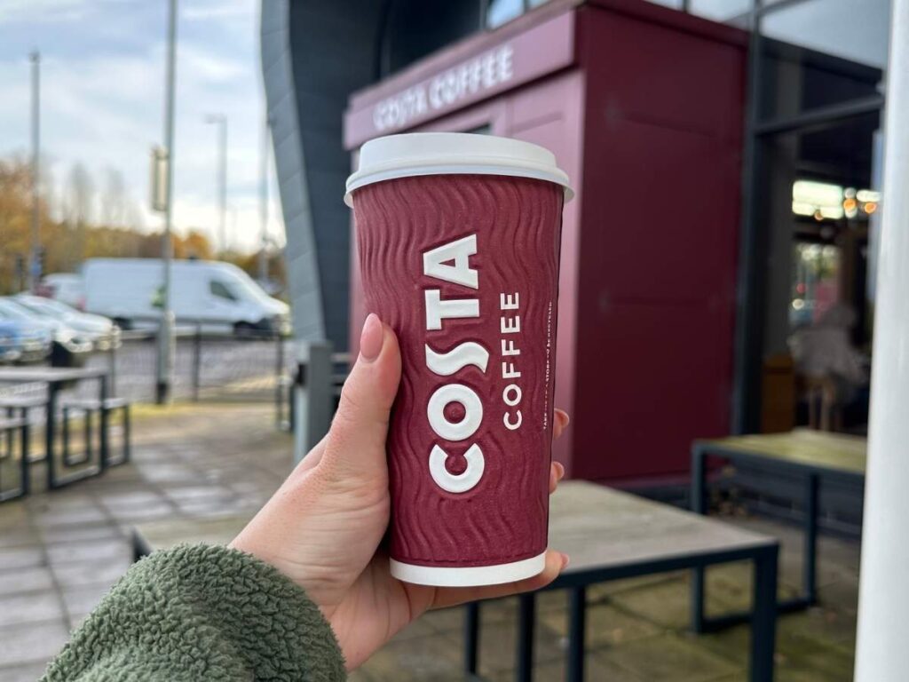 Hand holding a Costa Coffee cup to show how you can get a free coffee at Costa Coffee