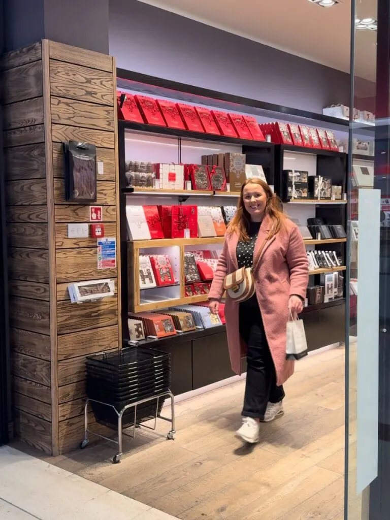 Chloe from Chloe's Deal Club in Hotel Chocolat shop with a gift bag holding a birthday free treat